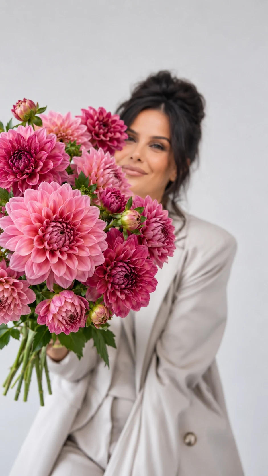 Person med en stor bukett rosa dahlior